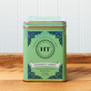A tin of Harney & Sons Peppermint Herbal tea sits on a wooden countertop.