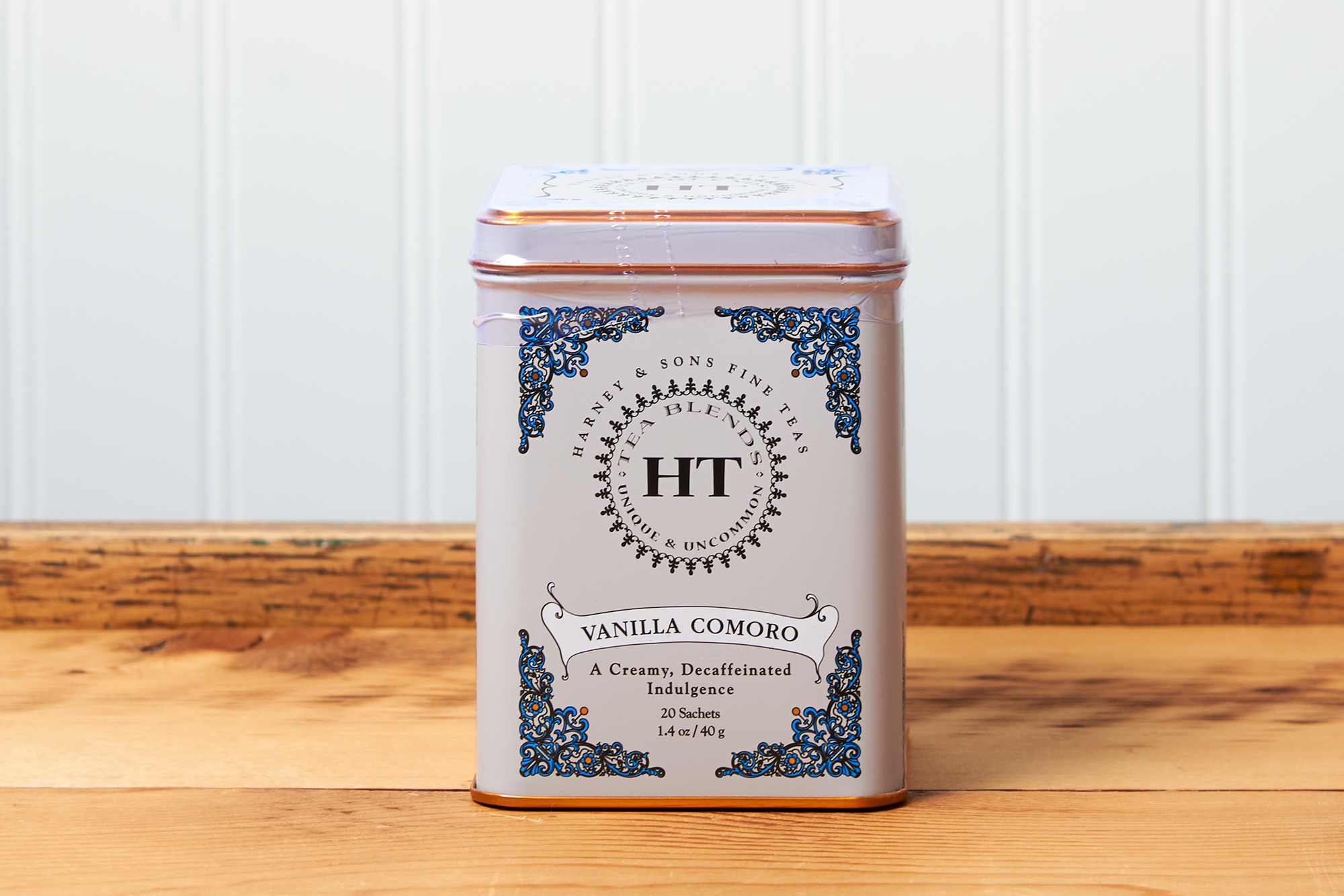 A tin of Harney & Sons Vanilla Comoro tea sits on a wooden countertop.
