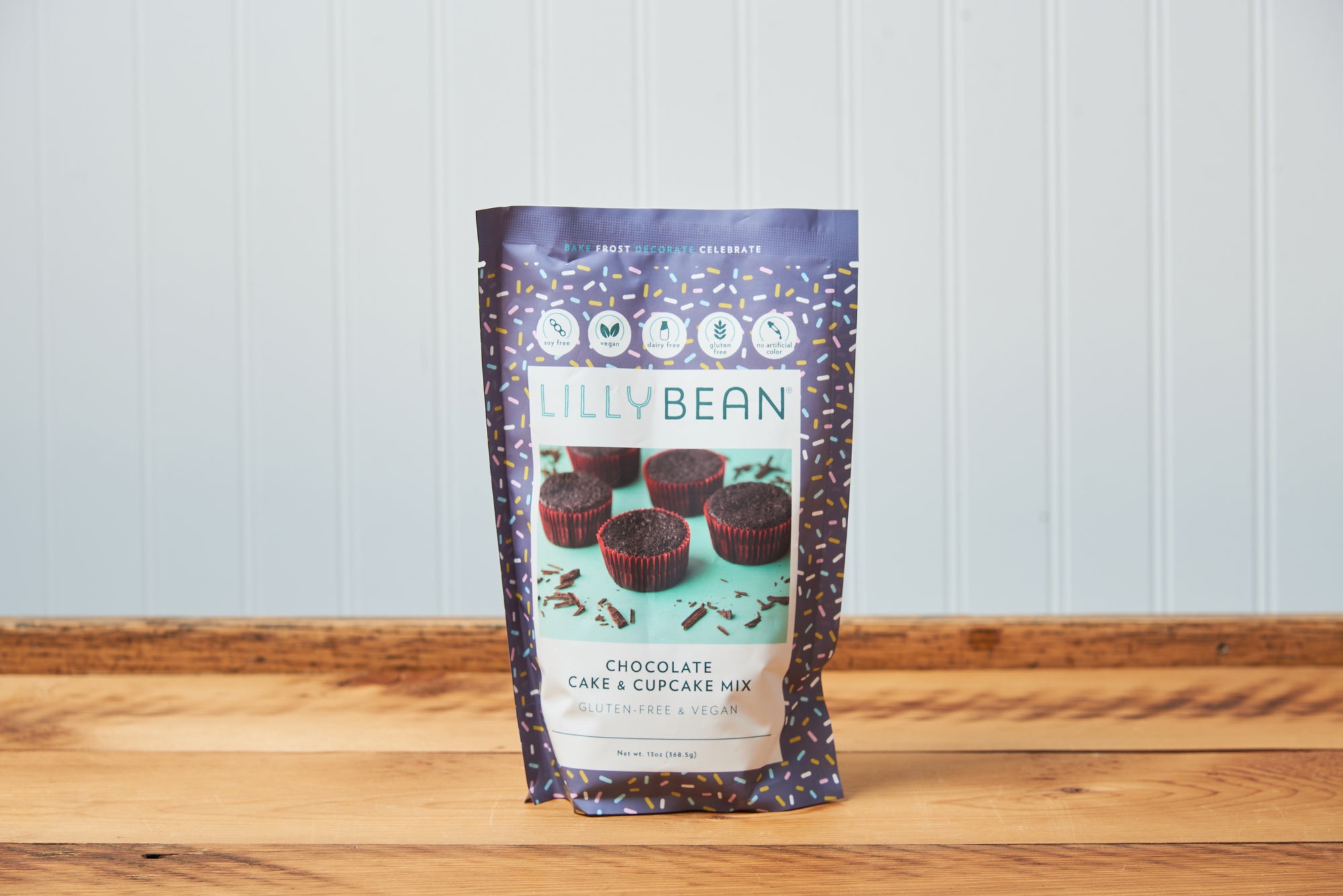 A bag of LillyBean Chocolate Cupcake Mix sits on a wooden tabletop. 