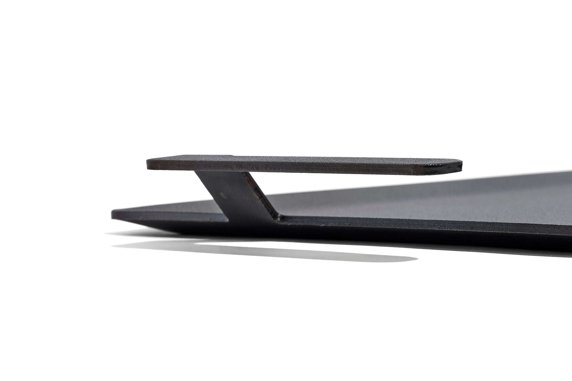 A close up on the handle of a Made In Seasoned Carbon Steel Griddle in front of a white background.