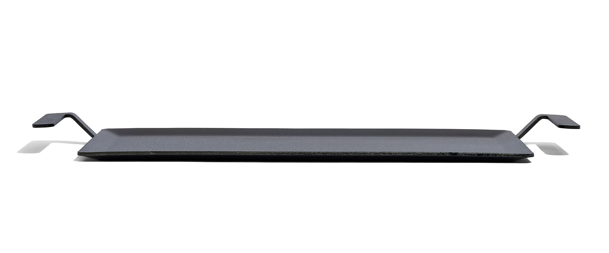 A Made In Seasoned Carbon Steel Griddle over a white background.