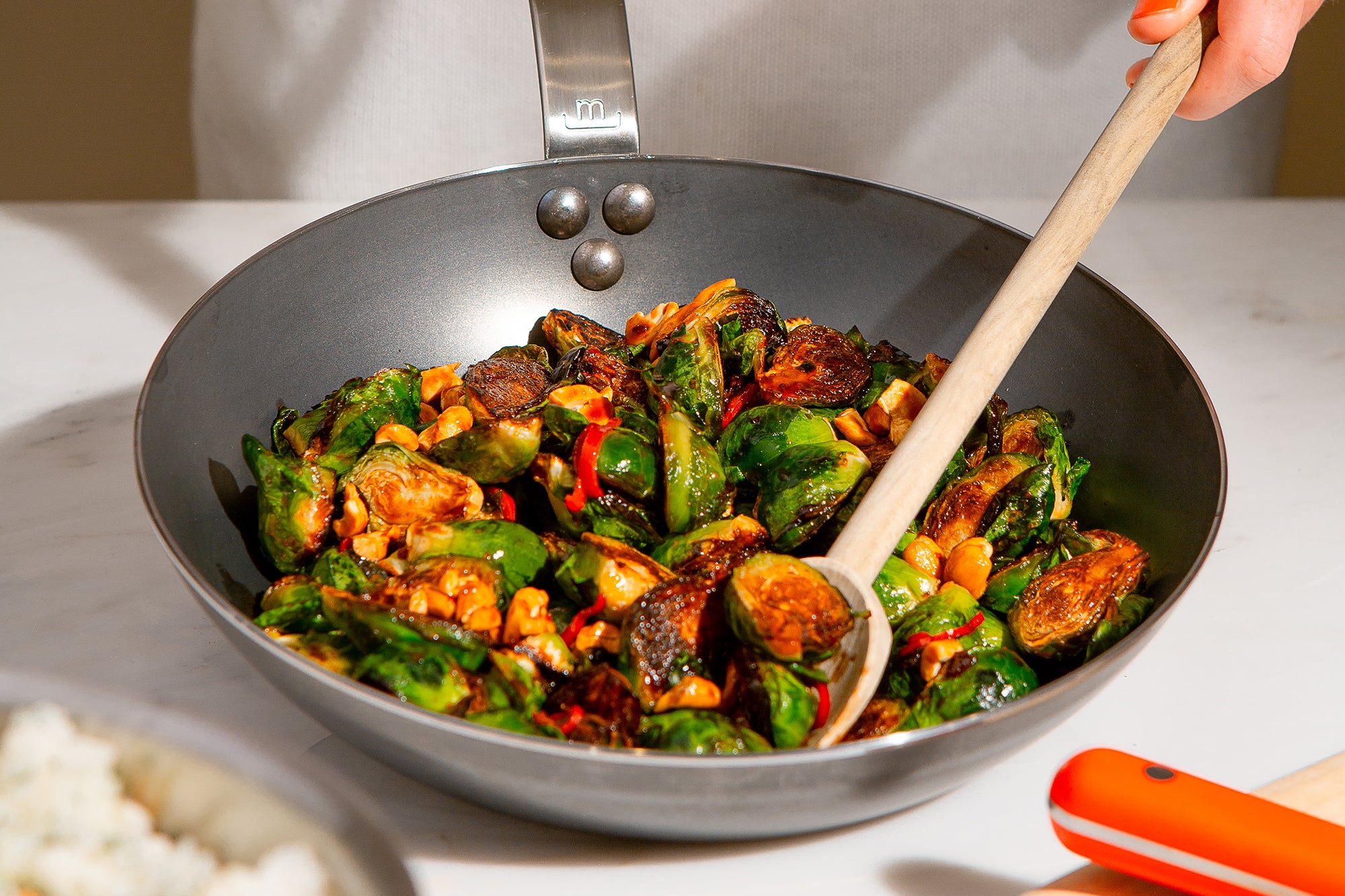 A person stir fries vegetables in a Made In Seasoned Carbon Steel Wok.