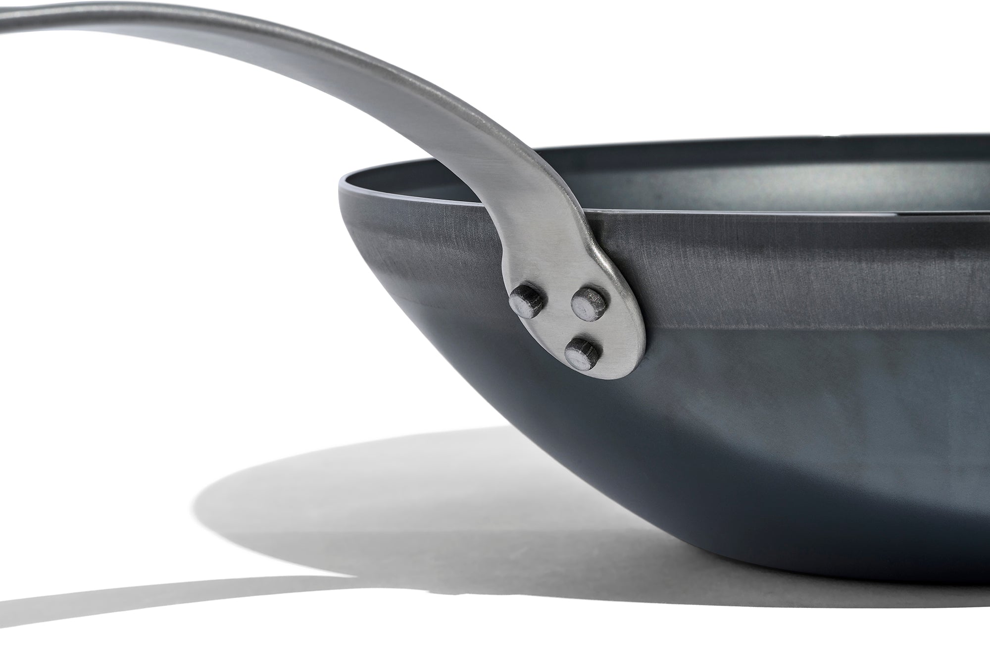 A close up of a Made In Seasoned Carbon Steel Wok in front of a white background.