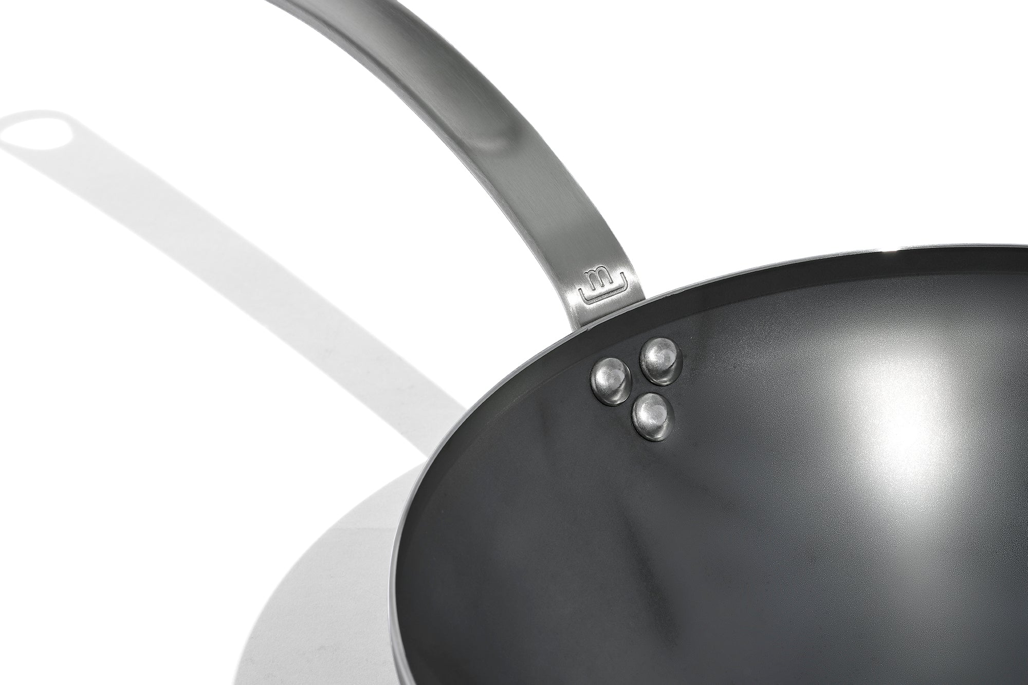 A close up of a Made In Seasoned Carbon Steel Wok in front of a white background.
