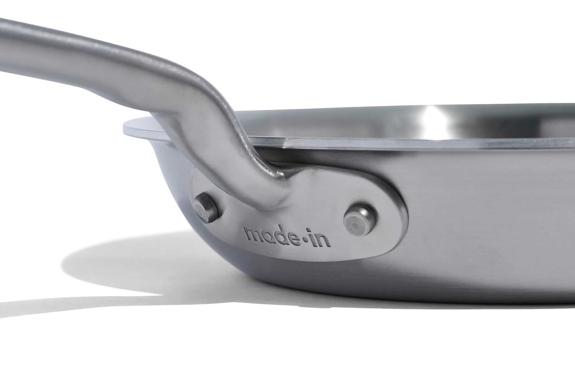 A close up of a Made In Stainless Clad Frying Pan in front of a white background.