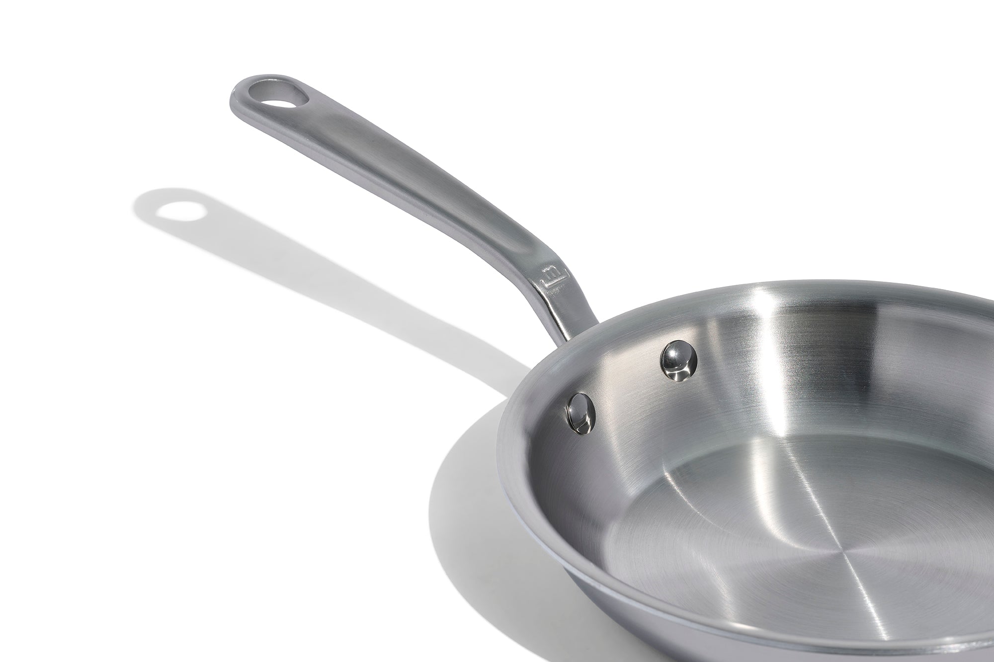 A close up of a Made In Stainless Clad Frying Pan in front of a white background.