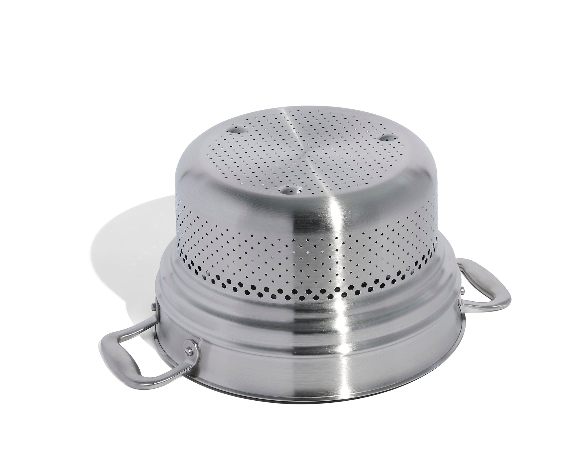 An upside down Made In Stainless Clad Pasta Insert in front of a white background.