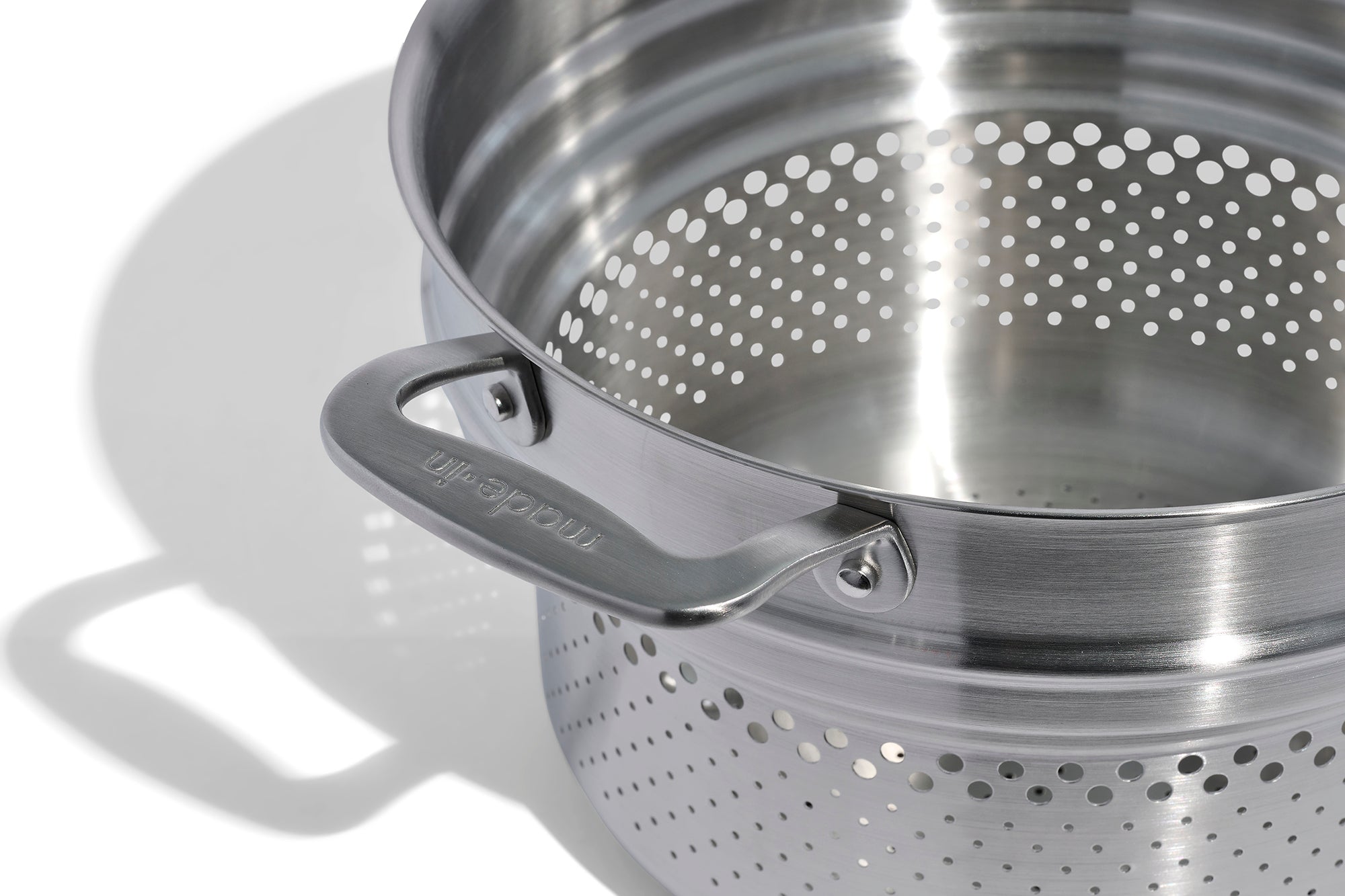 A close up of a Made In Stainless Clad Pasta Insert in front of a white background.