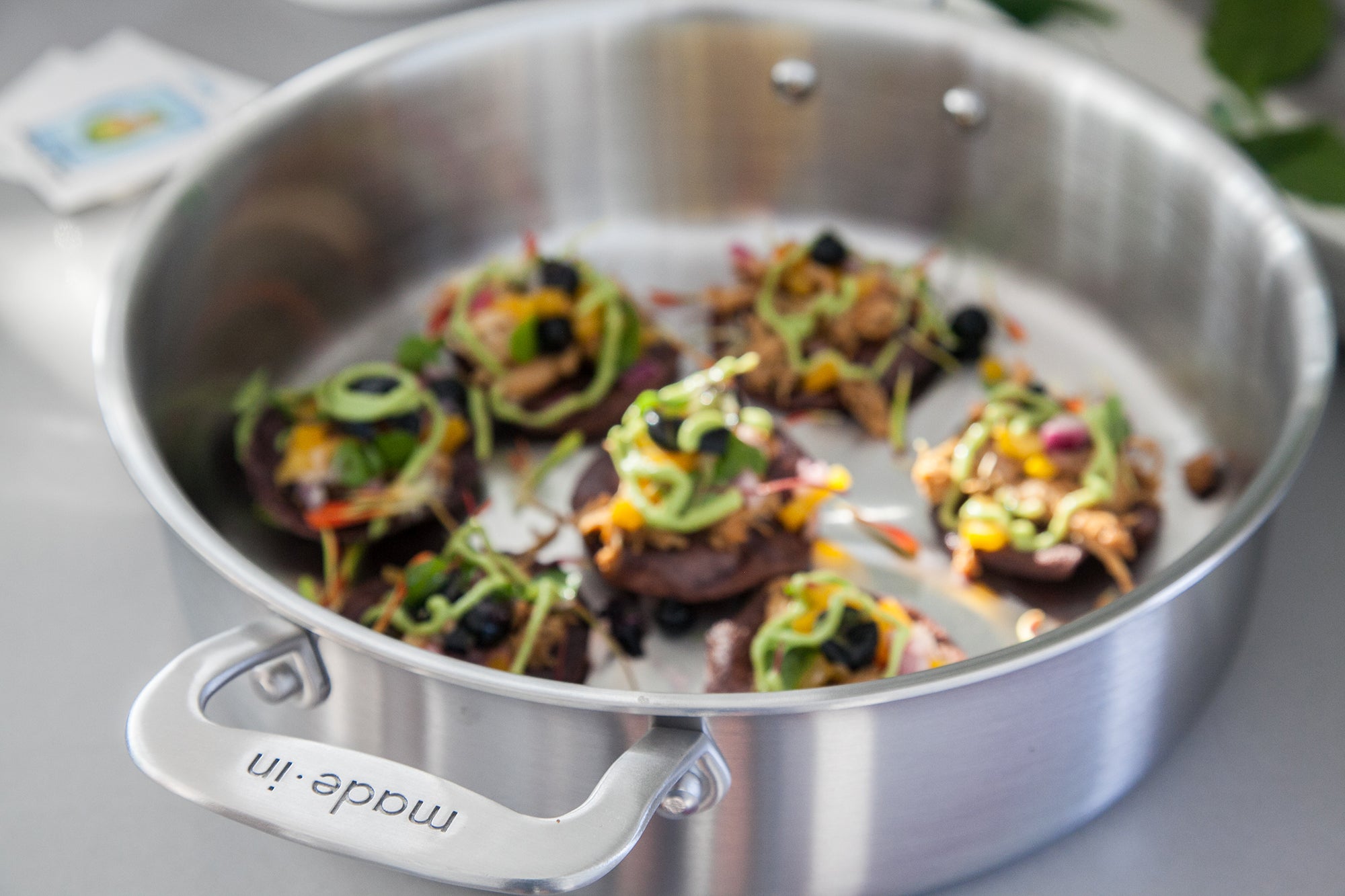 A Made In Stainless Clad  Rondeau with food in it sits on a countertop.