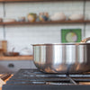 A Made In Stainless Clad Saucier sits on a stovetop.