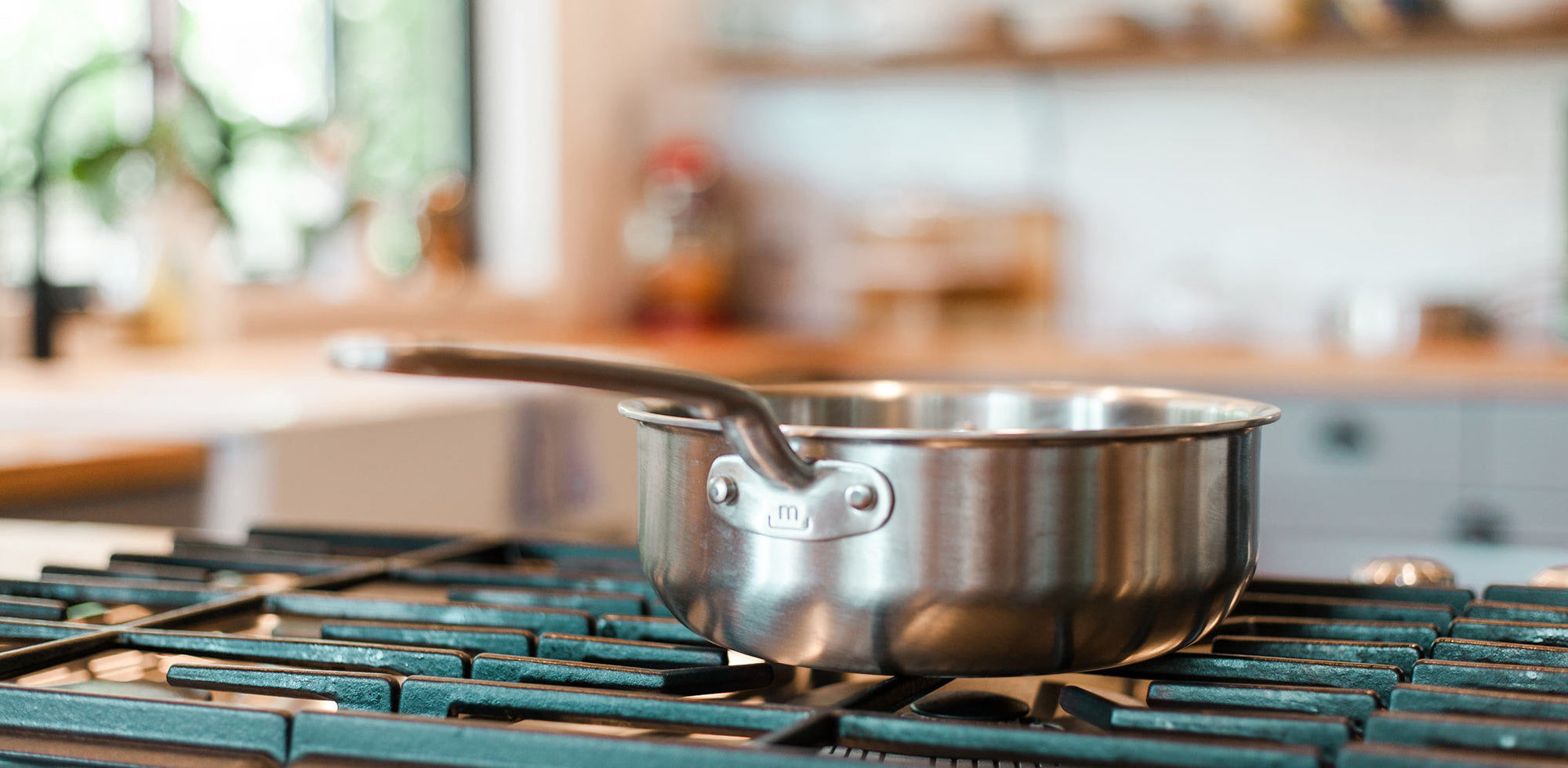 A Made In Stainless Clad Saucier sits on a stovetop.