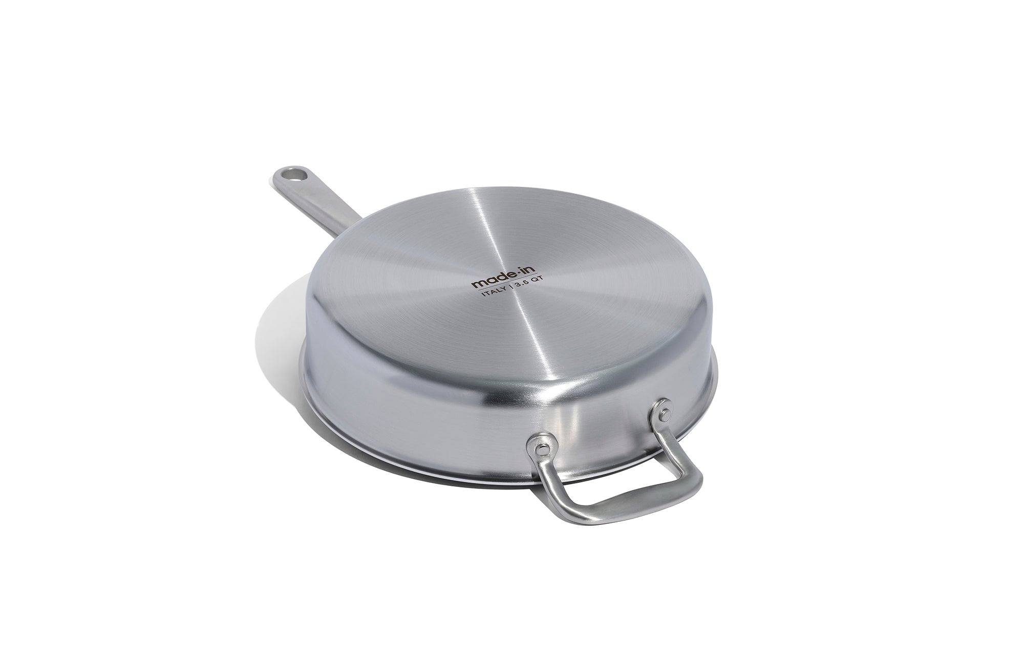 The underside of a Made In Stainless Clad Saute Pan with Lid in front of a white background.