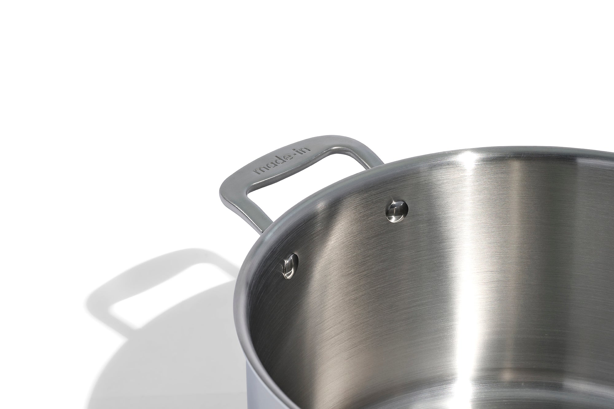 A close up of a Made In Stainless Clad Stock Pot in front of a white background.