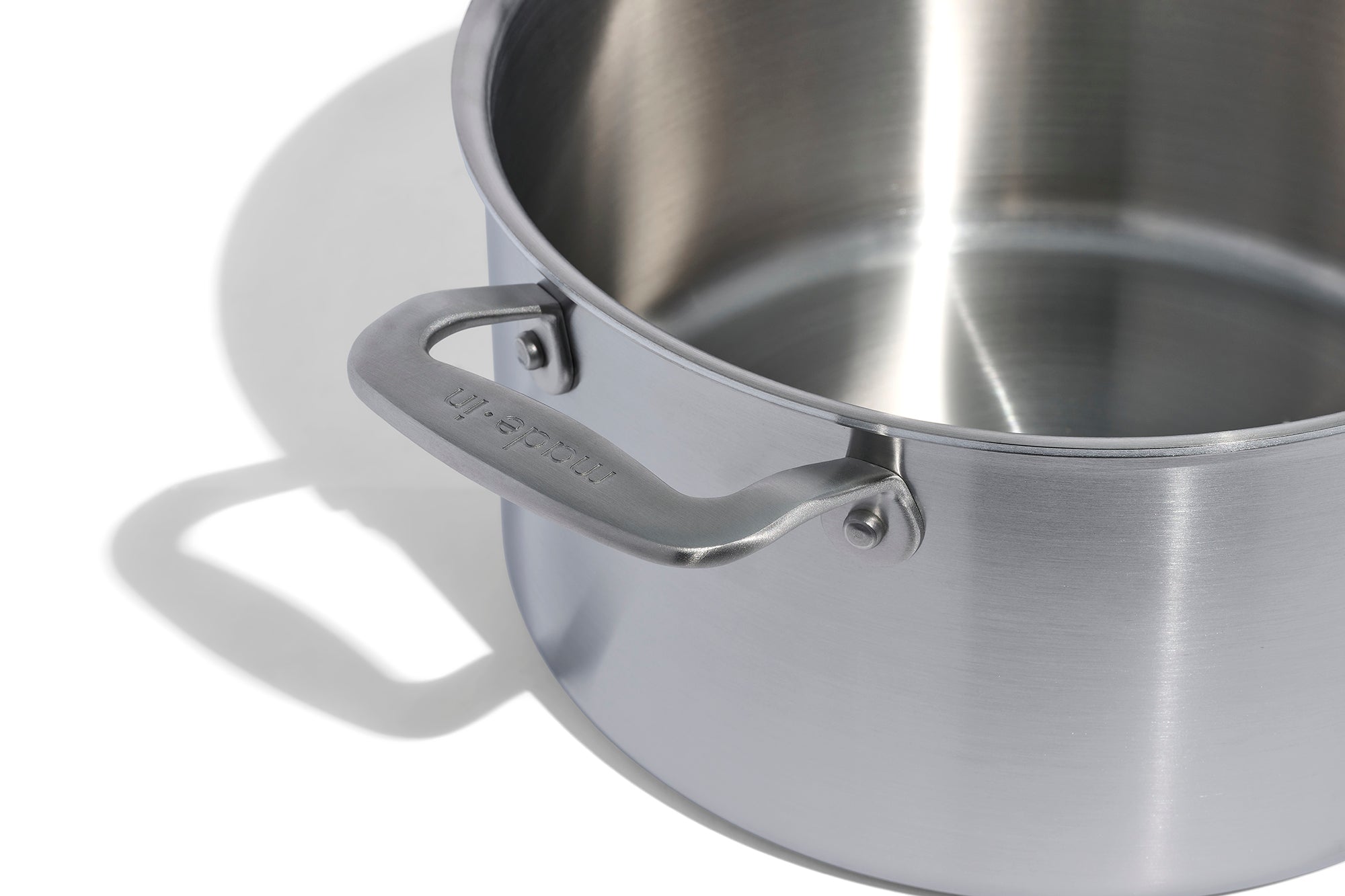A close up of a Made In Stainless Clad Stock Pot in front of a white background.