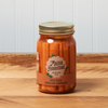 A jar of Maine Homestead Hot Dill Pickled Carrots sits on a brown wooden table.