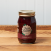 A jar of Maine Homestead Pickled Beets sits on a brown wooden table.