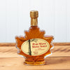 An 8 ounce Maine Maple Syrup maple leaf jar sits on a brown wooden table.