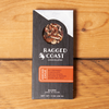 One Ragged Coast Chocolates Chocolate Ancho Chile and Roasted Pecan Bark sits on a wooden table.