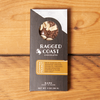 One Ragged Coast Chocolates Chocolate Coffee Peanut Bark sits on a wooden table.