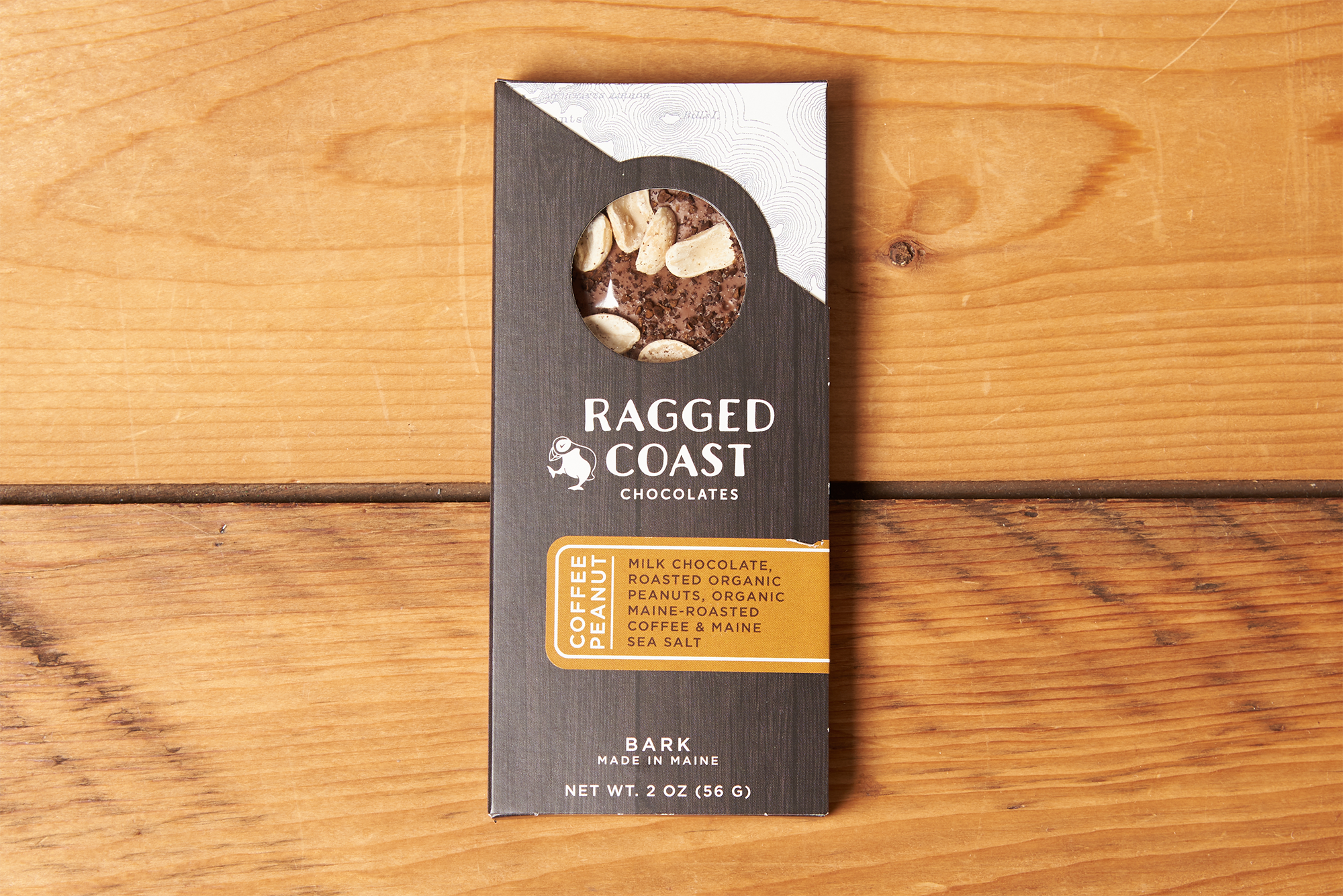 One Ragged Coast Chocolates Chocolate Coffee Peanut Bark sits on a wooden table.