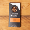 One Ragged Coast Chocolates Chocolate Honeyed Hazelnut Bark sits on a wooden table.