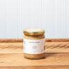 A jar of Raye's Maine Beer Company Lunch Mustard sits on a brown wooden table.