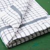 A grey Samuel Lamont Poli-Dry Towel sits on a green wooden tabletop.
