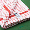 A red Samuel Lamont Poli-Dry Towel sits on a green wooden tabletop.