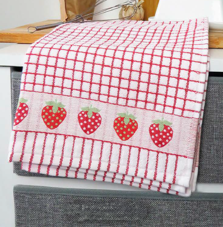 A red Samuel Lamont Poli-Dry Towel with woven strawberries drapes over a counter.