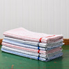 A stack of different color Samuel Lamont Poli-Dry Towels sit on a green wooden tabletop.