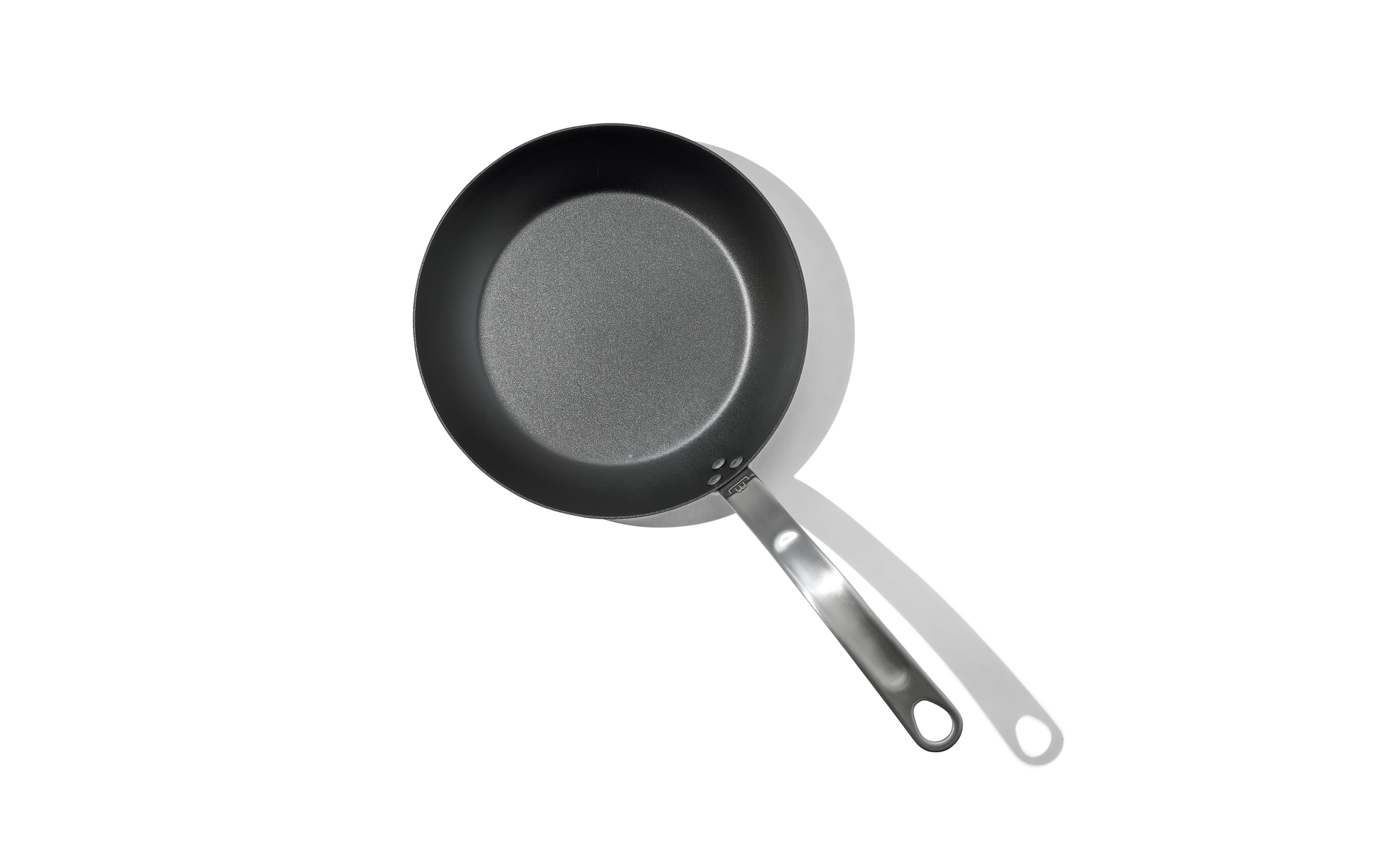 An overhead shot of a 10 inch Made In Seasoned Carbon Steel Fry Pan over a white background.