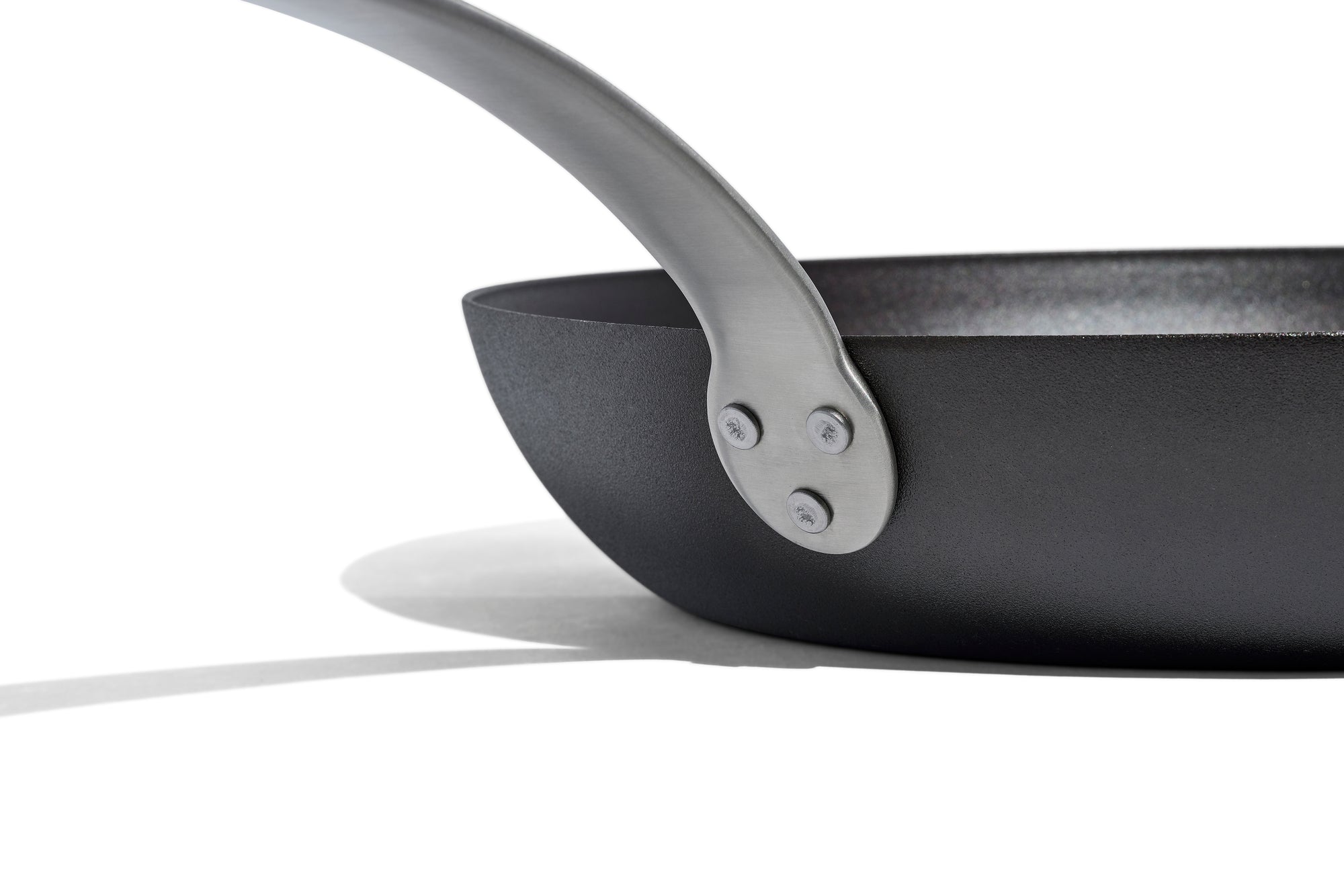 A close up shot of a Made In Seasoned Carbon Steel Fry Pan over a white background.