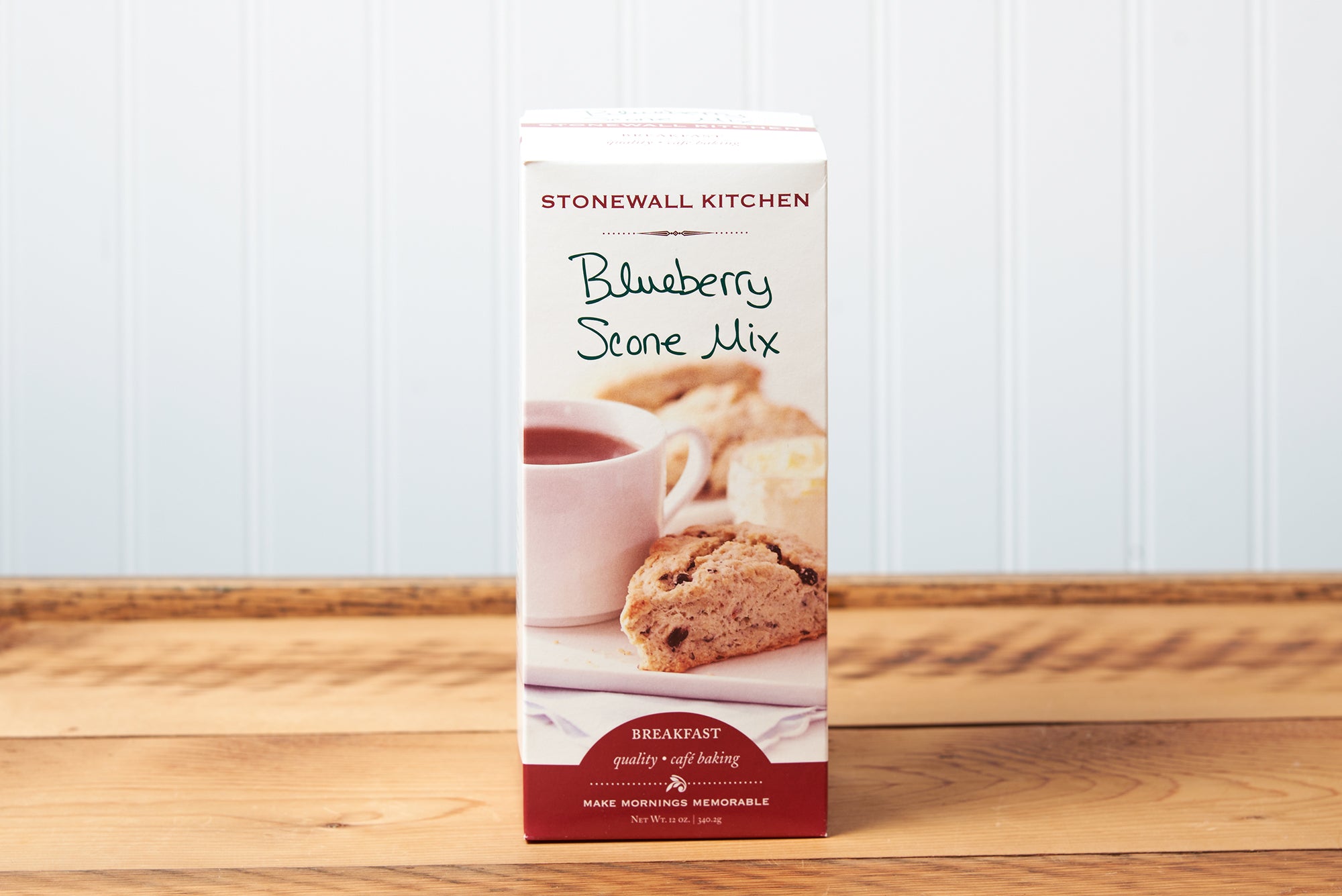 A box of Stonewall Kitchen Blueberry Scone Mix sits on a brown wooden table.