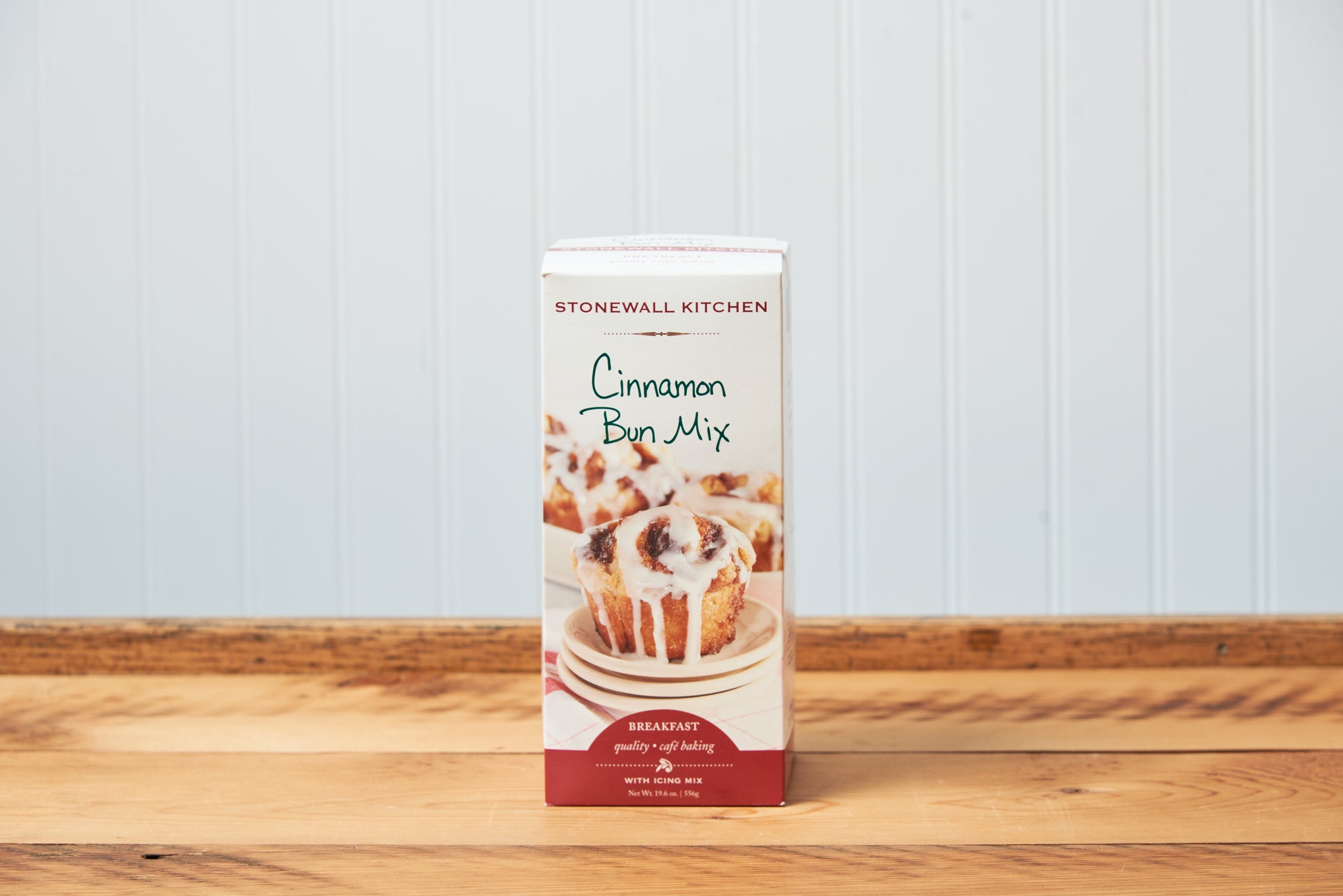 Stonewall Kitchen Cinnamon Bun Baking Mix sits on a wooden tabletop.