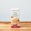 Stonewall Kitchen Orange Cranberry Scone Baking Mix sits on a wooden tabletop.