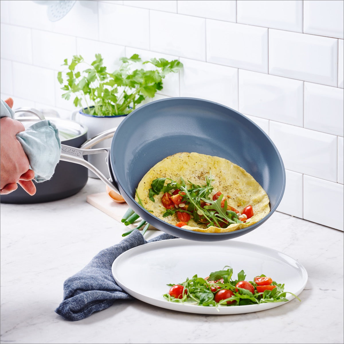 An omelette is plated from a Greenpan Paris Pro Ceramic Fry Pan.