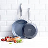 A set of 8" & 10" GreenPan Paris Pro Ceramic Fry Pans lean up against a white tile wall.