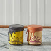 Two jars of Coop's hot fudge and salted caramel sauces on countertop
