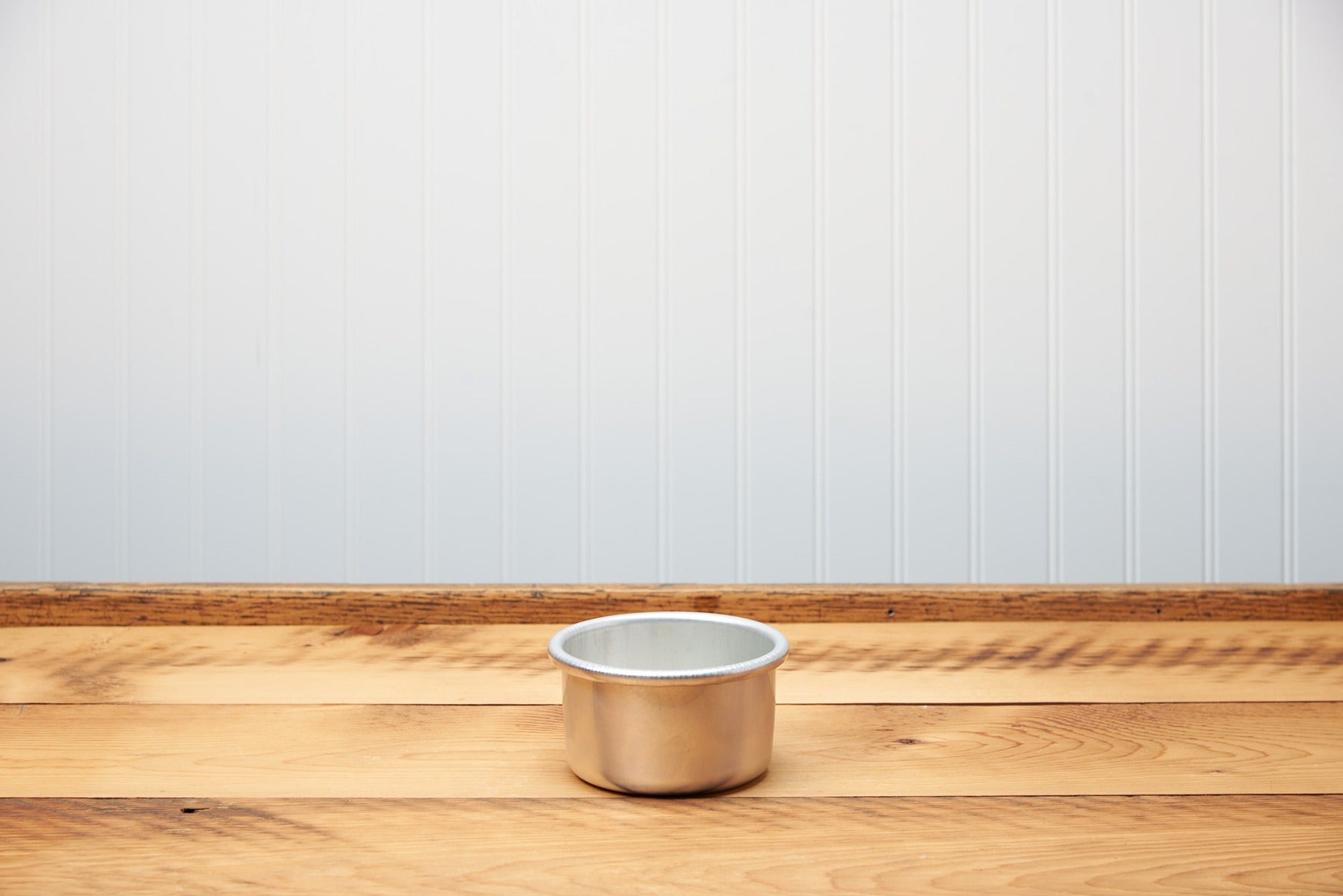 Copper cooking pot on a wooden table against a grey background