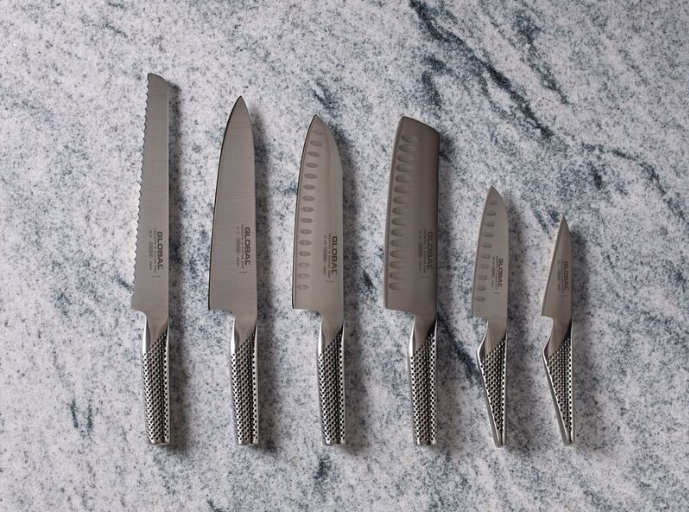 Assorted kitchen knives set on a marble countertop