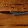 Damascus steel chef's knife with a wooden handle on a rustic wooden background