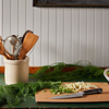 Kitchen counter with utensils, chopped vegetables, and a bowl of lemons.