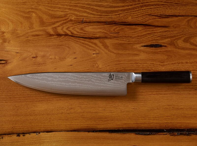 Japanese chef knife with Damascus steel blade on wooden surface