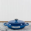 Blue Le Creuset cast iron casserole dish on a kitchen counter