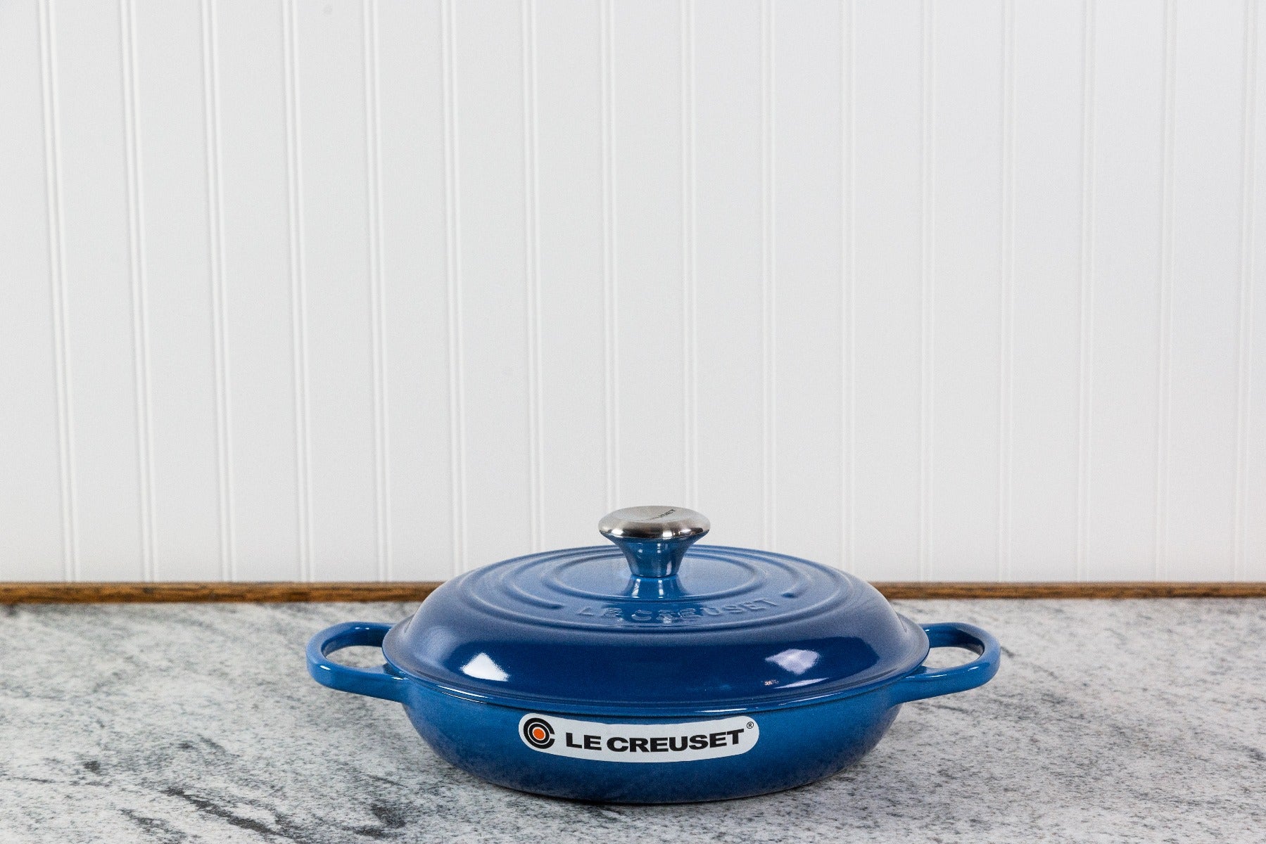 Blue Le Creuset cast iron casserole dish on a kitchen counter