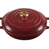 Red Le Creuset cast iron Dutch oven with gold knob on white background