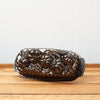 Vintage floral patterned cast iron loaf pan on a wooden table.