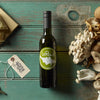 Bottle of Le Roux olive oil, assorted mushrooms, cheese wedge, and keys on wooden table.