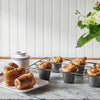 Freshly baked popovers on cooling rack with sugar container and flowers