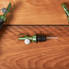 Olive oil pour spouts on a wooden surface with a bottle